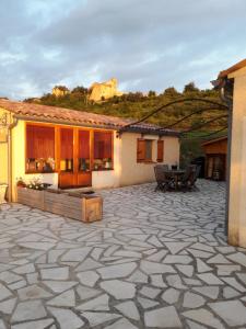 a patio with a table and a house at L'enchanteur in Saint-Jurs