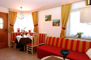 a living room with a red couch and a table at Dolomites Chalet CESA VEDLA -nature & silence in Ortisei