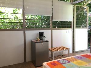 a room with a counter and a table and windows at La Perlita in Jacó