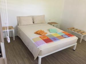 a bedroom with a bed with a quilt on it at La Perlita in Jacó