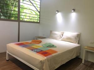 a bed with a quilt on it in a room at La Perlita in Jacó