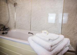 a bathroom with a bath tub with towels on it at Rye Hill Farm in Hexham