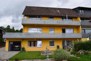 a yellow house with a balcony on top of it at Ferienhaus am Geiersberg in Walkenried