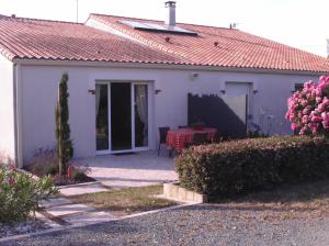 a small white house with a red roof at Gîte le logis in Mouchamps