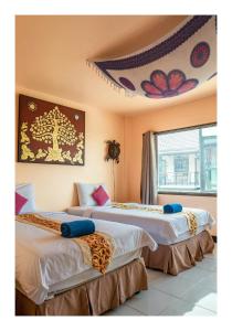 Duas camas num quarto com tecto em All in 1 Guesthouse em Chiang Mai