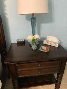 a table with a lamp and flowers on it at Huffman House Bed & Breakfast in Minden