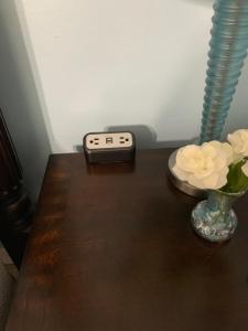 a remote control sitting on a table next to a vase with flowers at Huffman House Bed & Breakfast in Minden
