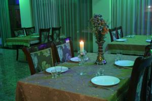 una mesa de comedor con una vela y platos y sillas en Hotel Noy en Goris