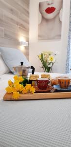 - un plateau avec de la nourriture et 2 tasses et des fleurs sur le lit dans l'établissement Martin Holiday Apartments, à Giardini Naxos