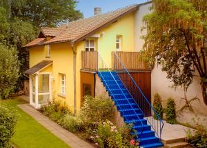 una casa amarilla con escaleras azules delante en Ferienhaus Aargau Bamberg en Bamberg