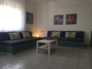 a living room with two blue couches and a table at Evdokia Suites in Gouves