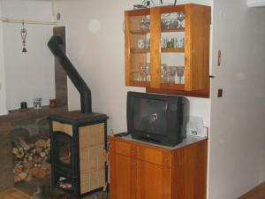 a living room with a television and a wood stove at Krkonosska Chalupa in Semily