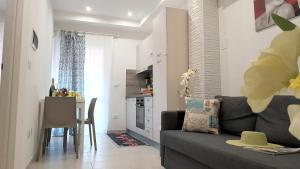 a living room with a couch and a kitchen at Martin Holiday Apartments in Giardini Naxos