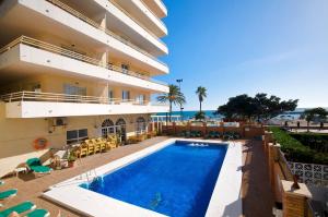 a hotel with a swimming pool in front of a building at Stellamar - Paseo Maritimo in Fuengirola