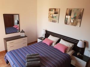 コラレホにあるVilla TODO BIENのベッドルーム1室(ピンクの枕と鏡付きのベッド1台付)