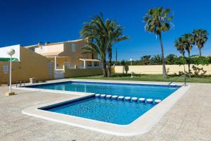 a swimming pool in front of a house with palm trees at Oasis De Paz in Mar de Cristal