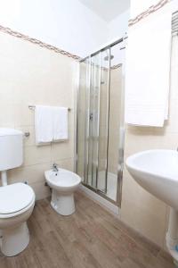 een badkamer met een toilet, een wastafel en een douche bij Hotel Piola in Milaan