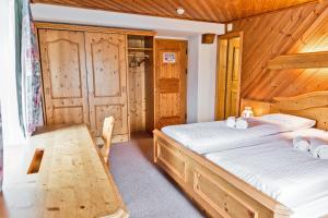 a bedroom with two beds and a table at Hotel Bernina Hospiz in Berninahäuser