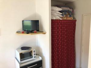 a room with a microwave and a tv on a shelf at Bois d'Aurouze SuperDévoluy in Les Cypières