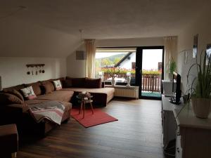 ein Wohnzimmer mit einem Sofa und einem TV in der Unterkunft Ferienwohnung Glück Auf in Walkenried