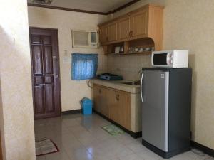 a small kitchen with a refrigerator and a microwave at Sunrise Apartelle in Olongapo