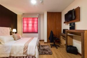 Habitación de hotel con cama y ventana roja en Hotel Boutique Castilla de Léon, en Cuenca