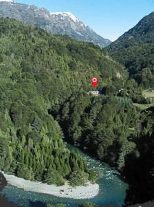 una señal roja de alto sobre un río en una montaña en La Confluencia Lodge en El Bolsón