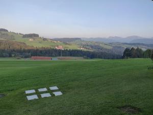 a green field with three crosses in the grass at Ferienwohnung Nagelfluh Allgäu in Oberreute
