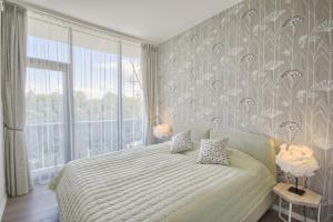 a bedroom with a bed and a large window at Korio Apartments, Druskininkai in Druskininkai