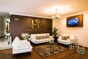 a lobby with white couches and a sign on a wall at Hotel Boutique Castilla de Leòn in Cuenca