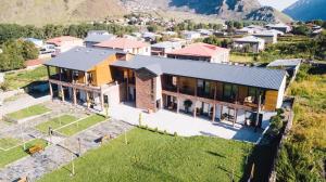 uma vista aérea de uma casa com montanhas ao fundo em Green Sheep Boutique Hotel em Kazbegi