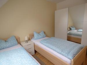 a bedroom with two beds and a mirror at Ferienapartment ''Zum Stollenkönig'' in Neustadt/Harz