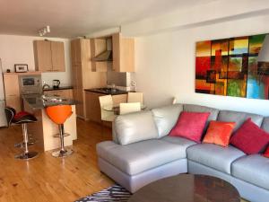a living room with a couch and a kitchen at City Centre Belfast Free Parking in Belfast