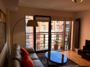 a living room with a couch and a glass table at City Centre Belfast Free Parking in Belfast
