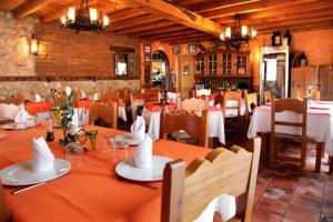a dining room with tables and chairs in a restaurant at El Rincon del Labrador in La Santa Espina