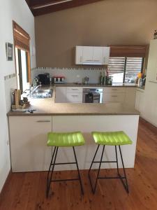 a kitchen with two green stools at a counter at Private Room In Everton Hills in Brisbane