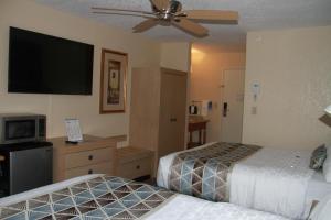 a hotel room with two beds and a flat screen tv at Baymont by Wyndham Stevens Point in Stevens Point