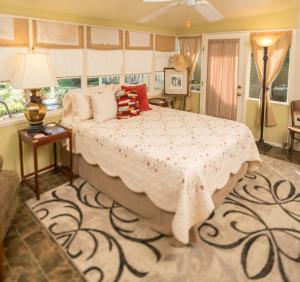a bedroom with a bed and a table with a lamp at Studio B Guest House in Fredericksburg