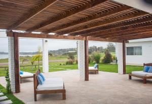 a patio with chairs and a wooden pergola at Aparthotel la Música y el Mar in Maldonado