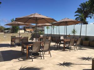 a patio area with chairs, tables and umbrellas at Sandy Cove Apartments in The Entrance