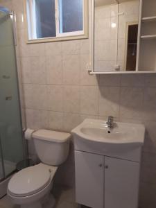 a white bathroom with a toilet and a sink at Cabañas Nortesur in Coihaique +16 photos