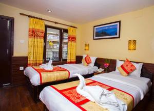 Habitación de hotel con 3 camas y toallas. en Hotel Trip Pokhara, en Pokhara