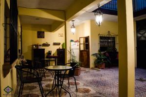 a room with a table and chairs and a refrigerator at Maison Bougainvillea in Antigua Guatemala