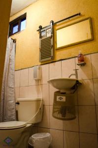 a bathroom with a toilet and a sink and a mirror at Maison Bougainvillea in Antigua Guatemala