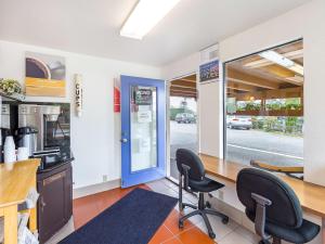 a kitchen with two chairs and a counter with a blue door at Motel 6 Gold Beach in Gold Beach