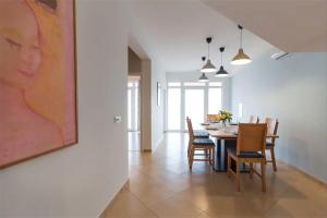 a dining room with a table and chairs and a painting at Apartments Hana in Pula