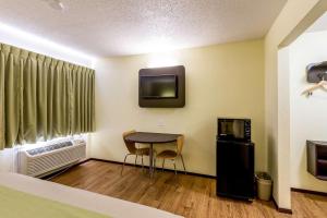 Zimmer mit einem kleinen Tisch und einem TV sowie einem Zimmer in der Unterkunft Motel 6-Troy, IL in Troy
