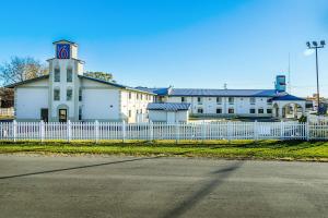 a white building with a white fence and a clock tower at Motel 6-Urbana, IL in Champaign