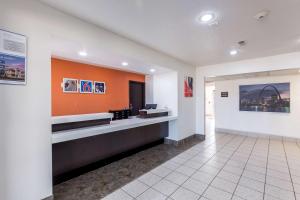 a lobby of a building with an orange wall at Motel 6-Troy, IL in Troy