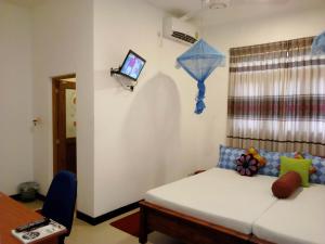 a bedroom with a bed and a tv on the wall at Miheen Hotel & Resort - Anuradhapura in Mihintale +37 photos